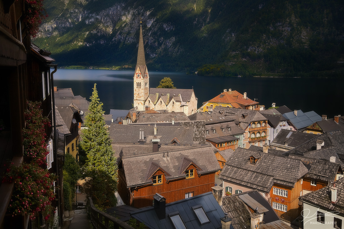 Hallstatt | View over the roof tops of city center with Evangelical Church of Christ (Evangelische Christuskirche) and lake Hallstätter See
<br>
Image taken from the balcony of a house in the upper side of the town