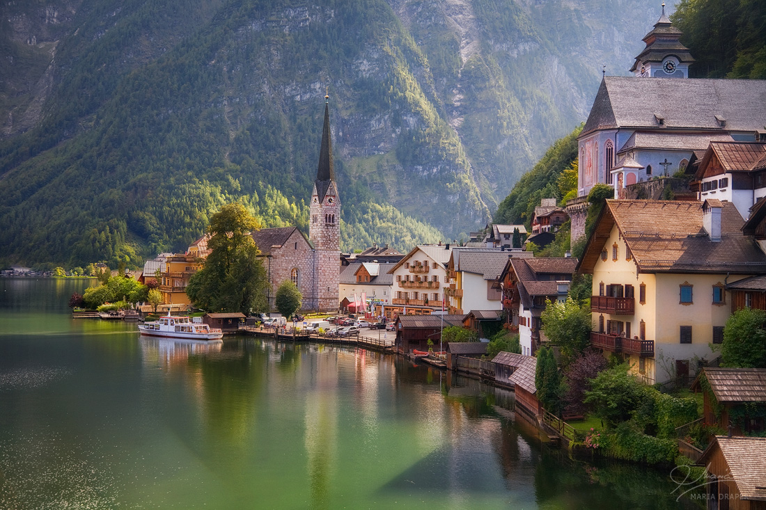 Hallstatt, Austria | Afternoon view of Hallstatt village reflecting in Hallstatter See (lake) with the Protestant Parish Church on the left and Catholic Parish Church on the right as seen from Aussichtspunkt on Gosaumuhlstrasse.
