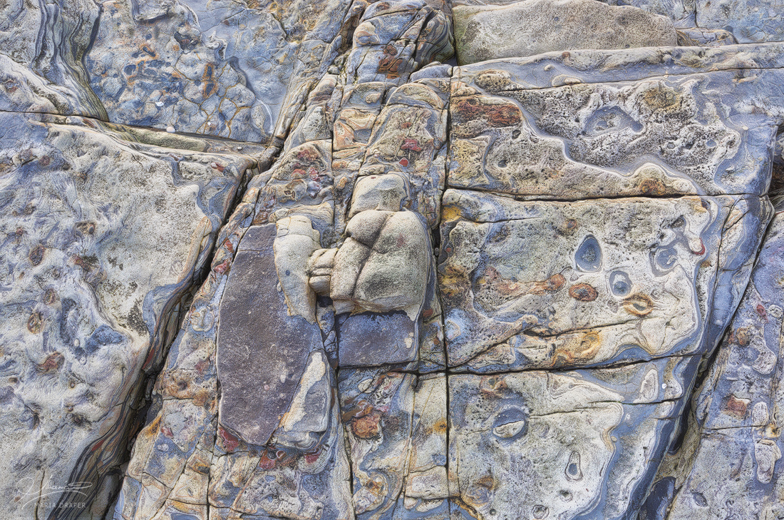 Sea Treasures | Textured rock with colorful designs resembling a variety of faces