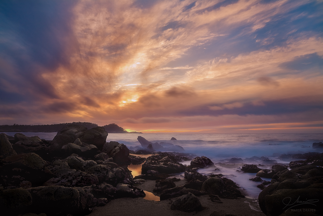 Carmel Meadows Sunset | Two small water pools are formed between the rocks during a spectacular sunset seen from the Carmel Meadows beach.  Point Lobos Peninsula is visible in the background.