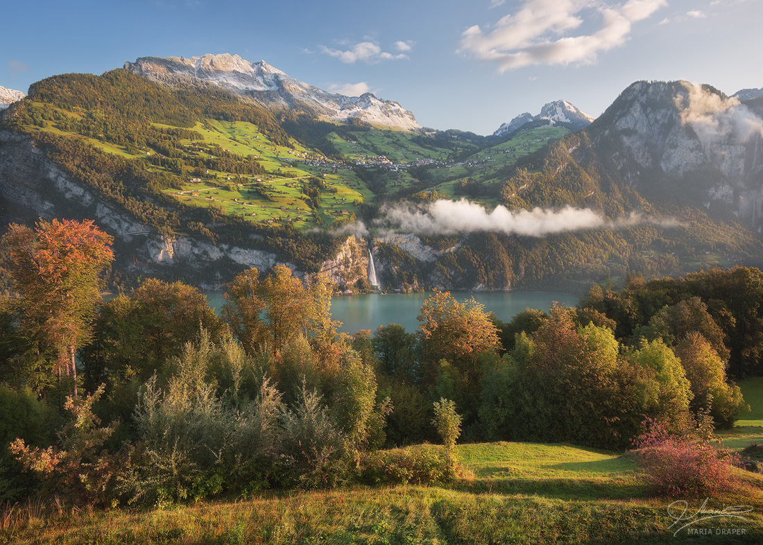 Amden, Switzerland | Autumn morning light over an idyllic Swiss mountain village situated above a turquoise lake and a waterfall.