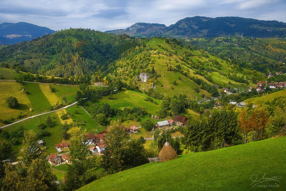 Brasov | Green rolling hills and hay stack in Brasov county, Romania
